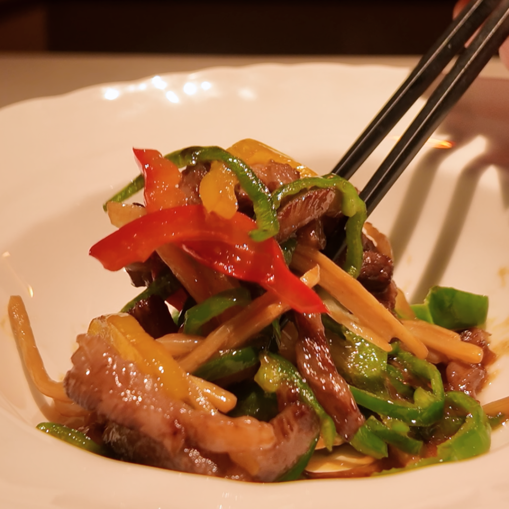 牛カルビを使った贅沢な青椒肉絲。赤と緑のピーマンが鮮やかに映え、肉の旨味と彩りが食欲をそそる春の中華一品料理。