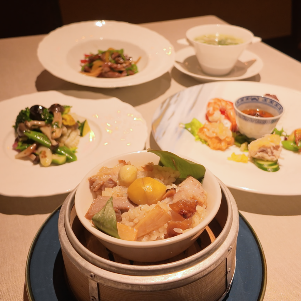 神戸壺中天の季節限定『春さき中華フェア』コース全皿が並ぶ写真。正面には具沢山の中華おこわが置かれ、立春を先取りした春の素材を使った華やかな中華料理が一度に見渡せる。