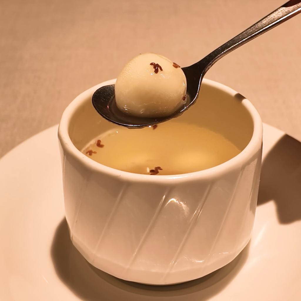 湯圓を温かい台湾ぜんざいとともにスプーンですくい上げたカット。白玉団子のやわらかさと優しい甘さが伝わる、春を感じる中華デザート。