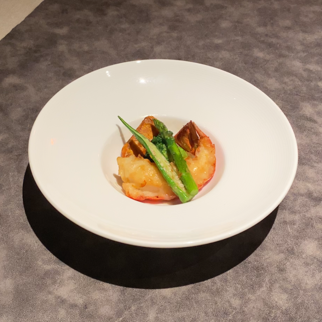 ディナーコースのオマール海老炒め。濃厚な旨みと香ばしさが際立つ豪華な一皿