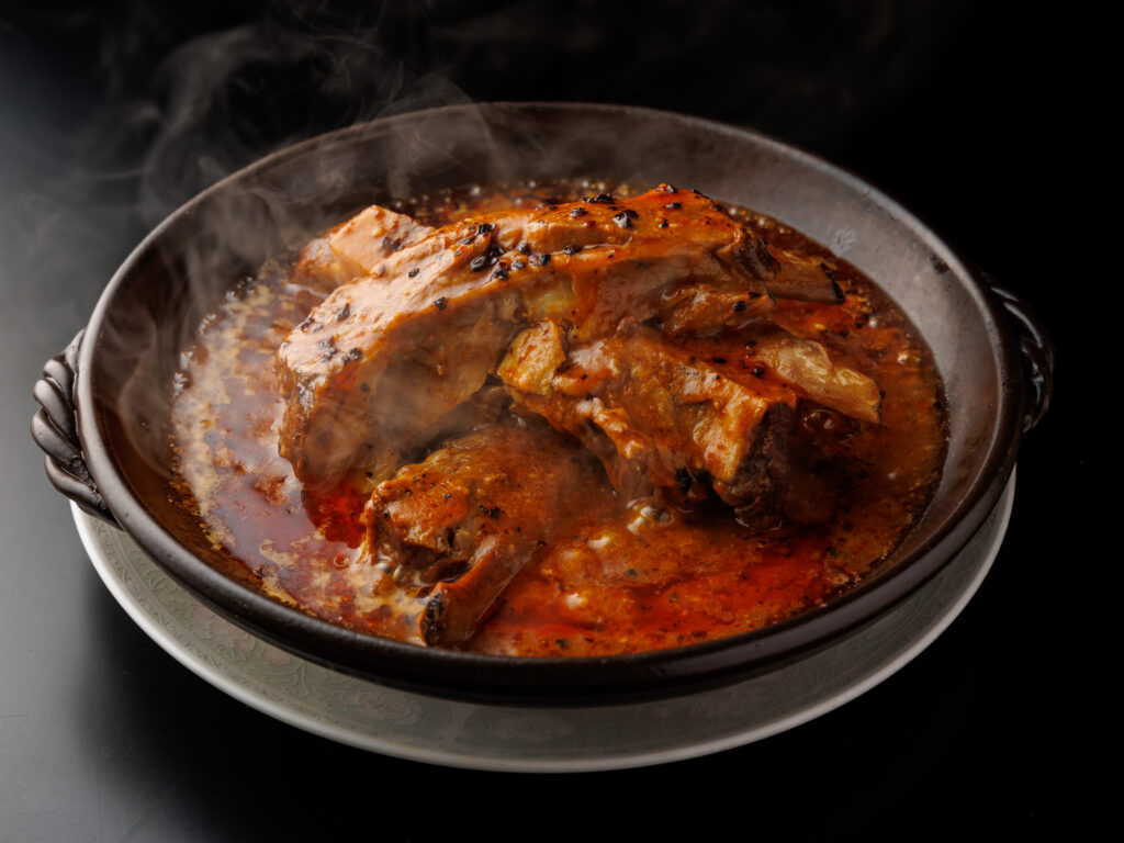 骨付き肉の旨みと香辣醤の辛味が織りなす四川の贅沢煮込み