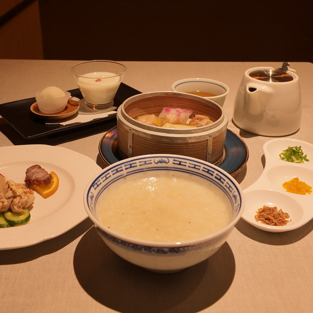 中華レストラン神戸壺中天の新メニュー〈ブランチ粥セット〉全景。前菜3種、点心4種、自家製デザート、選べる中国茶が並び、ボリューム感と華やかさが伝わるセット内容。