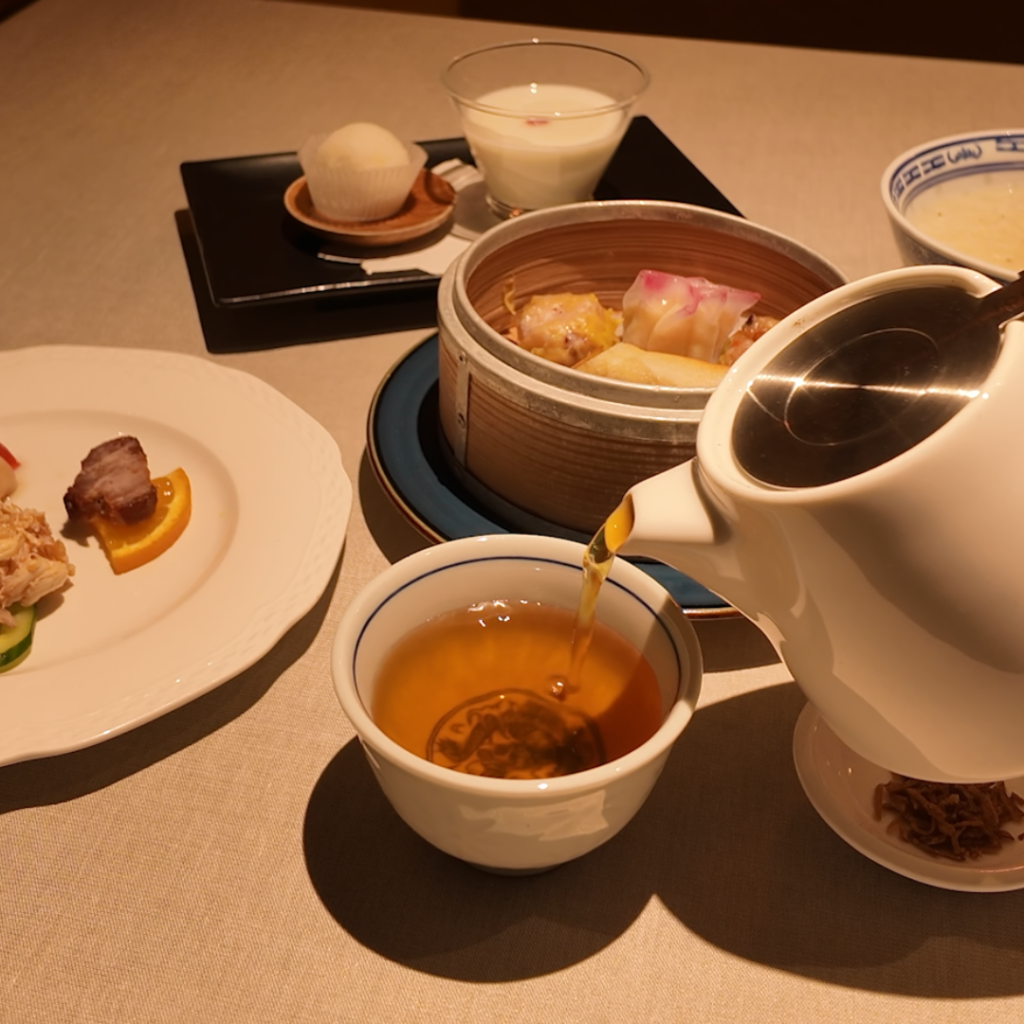 壺中天のブランチ粥セットで提供する中国茶をポットから注ぐ様子。ジャスミン茶・龍井茶・プーアル茶など、身体を温める優しいお茶の雰囲気が伝わる一枚。