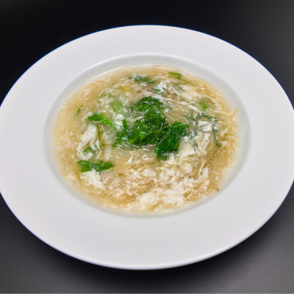 フカヒレと菜の花の煮込み。上品なフカヒレに春の菜の花のほろ苦さを合わせた繊細な味わい。季節感をたたえる上質な一品。